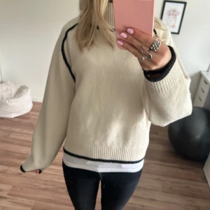 Beige stickad tröj - Supermysig syickad tröja med svarta detaljer och jag hals. Perfekt till hösten💕