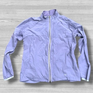 Ljuslila vindjacka från Nike XL - Nike vindjacka i ljuslila med hel dragkedja och sportig meshfoder. Jackan har ståkrage och diskret Nike-logga framtill. Perfekt för dig som gillar en clean och fräsch look. Clima Fit-materialet gör den extra skön och lätt att bära.