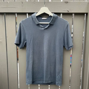 Blå piké från Filippa K - Snygg blå piké från Filippa K i storlek XS. Gjord i bomull och väldigt mjuk och skön. Perfekt för sommaren. Tveka inte på att höra av dig vid frågor eller funderingar!