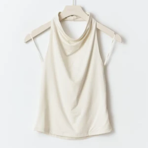 Halterneck topp - Säljer en stilren beige halternecktopp med öppen rygg. Toppen är aldrig använd och är helt slutsåld i butik. Från Gina Tricot i storlek M men passar även S💕💕