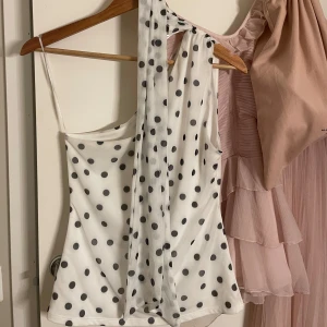 Vit prickig oneshoulder topp - Snygg festligtopp som är helt slutsåld! Skriv vid funderingar och pris kan diskuteras vid snabb affär!❤️