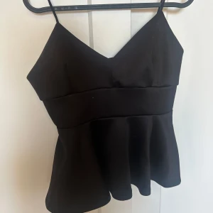 Svart topp med smala band - Så söt topp ifrån Gina!! Jag har knytit upp bandet på baksidan för att den ska sitta bättre!! Storlek M men kanske liten i storleken 💕💕