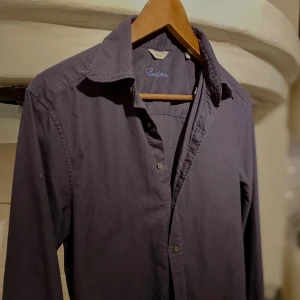 Mörkblå skjorta från Stenströms Slimline - Snygg mörkblå skjorta från Stenströms Slimline med klassisk krage och knäppning framtill. Skjortan är långärmad och tillverkad i bomull, perfekt för dig som gillar stilrena och enkla plagg. Passformen är slim och den har en stilren look utan mönster.