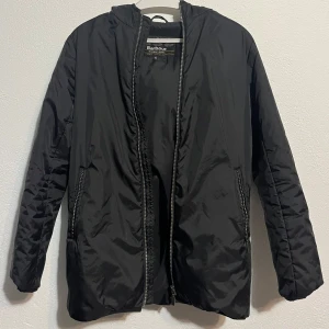Svart Jacka Barbour - Svart jacka från Barbour International i storlek XL i junior storlek så motsvarar typ XS i herr. Jackan har huva, dragkedja framtill och två fickor med dragkedja. Enkel och clean design som funkar till det mesta. 