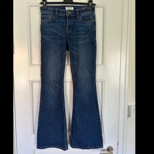 Blå bootcut jeans från Lindex - Snygga blå jeans från Lindex med klassisk bootcut-modell. Jeansen har normal midja, fem fickor och är tillverkade i ett mjukt denimtyg. 🫐