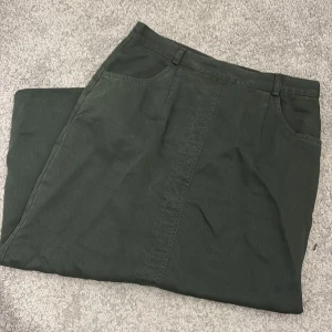 Mörkgrön långkjol med slits - Snygg mörkgrön långkjol med klassisk rak passform och slits framtillför extra rörelsefrihet. 