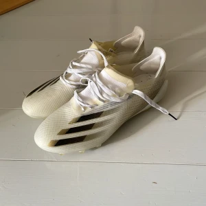 Adidas vita fotbollsskor med snörning - Säljer ett par vita Adidas fotbollsskor. Bra skick nästan som helt nya! Rätt så smala 