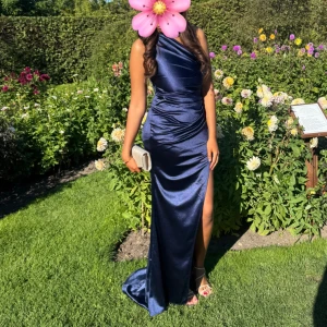 Marinblå balklänning  - Säljer den perfekta balklänningen!Super fin marinblå långklänning i satin med oneshoulder och snygg slits på sidan. Klänningen är enbart använd 1 gång därav priset💖💖💖