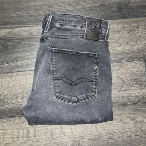 Replay Anbass Hyperflex Jeans  - Snygga svarta Replay Anbass Hyperflex jeans med smal passform och klassisk femficksdesign. Jeansen har diskreta slitningar och en mörk tvätt, samt Replay-logga på bakfickan. Midja 44cm, längd 102cm. JAG SKICKAR INGA FLER BILDER NÄR JAG BÄR JEANSEN :) s2