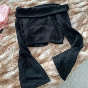 Svart ribbad offshoulder topp - Säljer en svart ribbad offshoulder topp med vida ärmar