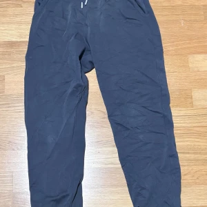 Svarta mjukisbyxor från Kappahl - Svarta mjukisbyxor från Kappahl i storlek 158. Byxorna har resår i midjan med snörning och är tillverkade i mjukt material som passar perfekt för chill eller träning. Klassisk rak passform med fickor på sidorna. Mycket bra skick. 