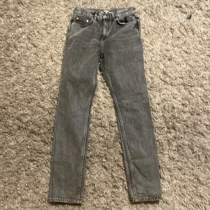 Grå straight jeans från Junkyard - Säljer ett par gråa straight fit jeans från Junkyard i storlek S. Jeansen har klassisk femficksdesign, raka ben och en snygg tvättad look. Perfekta om du gillar en enkel och stilren vibe.