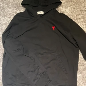 Ami hoodie - Svart hoodie från Ami med broderat rött hjärta på bröstet. Storlek L och är i väldigt bra skick. Inga defekter. Säljs för 1300👍