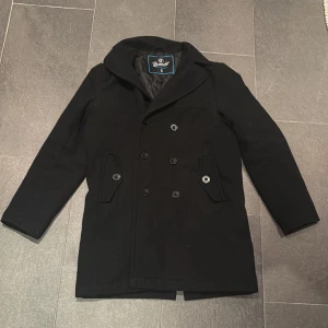 Dubbelknäppt rock - Ganska lång. Passar större storlekar. Inga bud