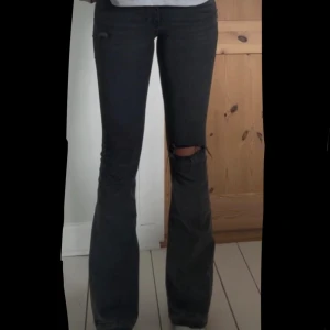Svarta bootcut jeans med slitningar - Säljer ett par svarta jeans med bootcut passform och snygga slitningar vid knäet. Från Gina tricot