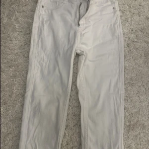 Vita jeansbyxor XS Gina Tricot Molly - Vita jeansbyxor från Gina Tricot, modell Molly i storlek XS. Klassisk femficksdesign med dragkedja och knapp framtill. Byxorna har en slim passform och är tillverkade i stretchigt bomullsmaterial för en bekväm känsla.