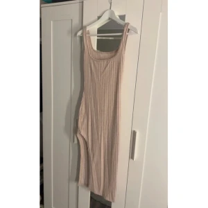 Beige ribbad klänning - Säljer en beige ribbad klänning som är ungefär knälång. Perfekt för varma dagar eller att styla med en jacka.