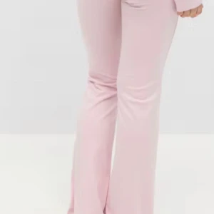 Ljusrosa bootcut byxor i mjukt tyg - Säljer ett par ljusrosa bootcut byxor i ett mjukt och stretchigt material. Byxorna har en smickrande passform med utsvängda ben och hög midja. Perfekta för dig som gillar en trendig och bekväm stil. Alldrig andvända med lapp kvar i original paket