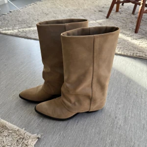 Beige folded boots från Pull&Bear, storlek 38 - Beige folded boots från Pull&Bear med mockaliknande yta och 3cm klack. Använda ca 3 gånger och är nästan i nyskick. Nypris på ca 699kr och jag säljer för 230kr❣️