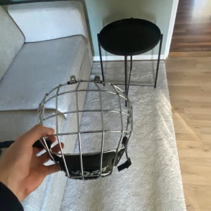 JOFA hockeygaller 480M chrome - Säljer ett klassiskt JOFA hockeygaller modell 480M i silverfärgad metall med svart hakskydd och justerbara remmar. Perfekt för dig som vill sticka ut lite extra på isen. Passar hjälmar med fästen för galler.