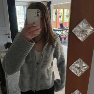 Stickad tröja - Supersnygg stickad tröja med dragkedja. Den har en hög hals men kan bäras på flera sätt. Mycket fräsch och knappt använd.