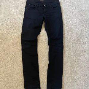 Svarta jeans från Nudie Jeans, W31 L34 - Byxorna är i bra skick, men har lagats vid skrevet (kolla bild), skriv vid frågor och funderingar! Modell: Tight long John