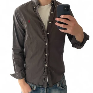 Mörkgrå skjorta från Ralph Lauren | S - Spegeln är smutsig! Inte plagget. Skjortan är i fint skick men har blivit lite blekt i armhålorna kolla bild! Skriv vid frågor och funderingar!