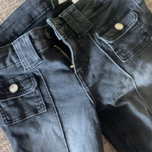 Svarta jeans med fickdetaljer - Snygga svarta jeans med coola fickor framtill med knappar. 