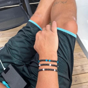 Svarta och blå pärlarmband - Du väljer  själv färg på  ett armband. stilrena pärlarmband med svarta, vita och blå pärlor. Armbanden har en enkel och modern design med små runda pärlor i olika färgkombinationer. Perfekt för dig som gillar att mixa och matcha accessoarer för en personlig look.