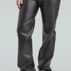 Svarta skinnbyxor med straight fit - Snygga svarta byxor i skinnimitation med klassisk rak passform. Byxorna har låg midja och femficksdesign, vilket ger en cool och tidlös look. Perfekta för dig som vill sticka ut med en edgy vibe. Passar till både sneakers och boots.