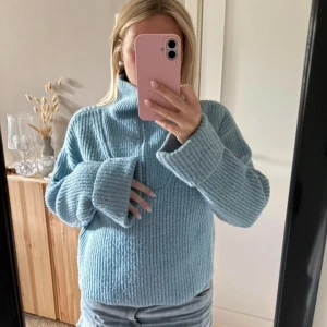 Ljusblå stickad half zip tröja - Supermysig ljusblå stickad tröja med half zip och hög krage. Tröjan har oversized passform, breda muddar och långa ärmar💕