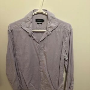 Lila skjorta Riley - Lila skjorta från Riley. Använd 3 gången och är i väldigt fint skick (bara lite skrynklig nu). Nypris 900kr mitt pris 220. Tveka inte på att höra av er vid frågor eller prisförslag!