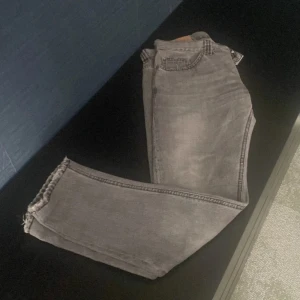 Grå jeans från Dondup med rå kant - Snygga grå jeans från Dondup med en blandning mellan raka och slimfit och rå, fransad kant nertill. Klassisk femficksmodell och diskret tvättad look. Jeansen är i bomull och har en stilren, enkel design som passar till det mesta.