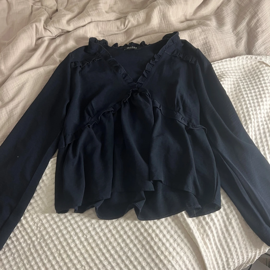 Mörkblå blus med volanger