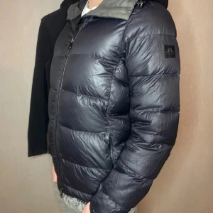 J.Lindeberg Jacka - Mörkblå jacka från j.lindeberg, köpt i j.lindeberg affären i nk. Den passar smalt och är i storlek medium. Inga skador förutom att dragkedjan är ur led på innerfickan. Jackan är riktigt varm, sparsamt använd genom en vinter. PRIS KAN DISKUTERAS! 👌🏼🔥