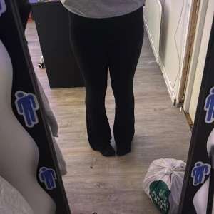 Svarta yogapants från Lager 157 - Svarta bootcut byxor från 157 i stretchigt material. Hög midja och tight passform upptill som släpper ut i ett snyggt utsvängt ben. Perfekta för dig som gillar en stilren och enkel look med lite edge.