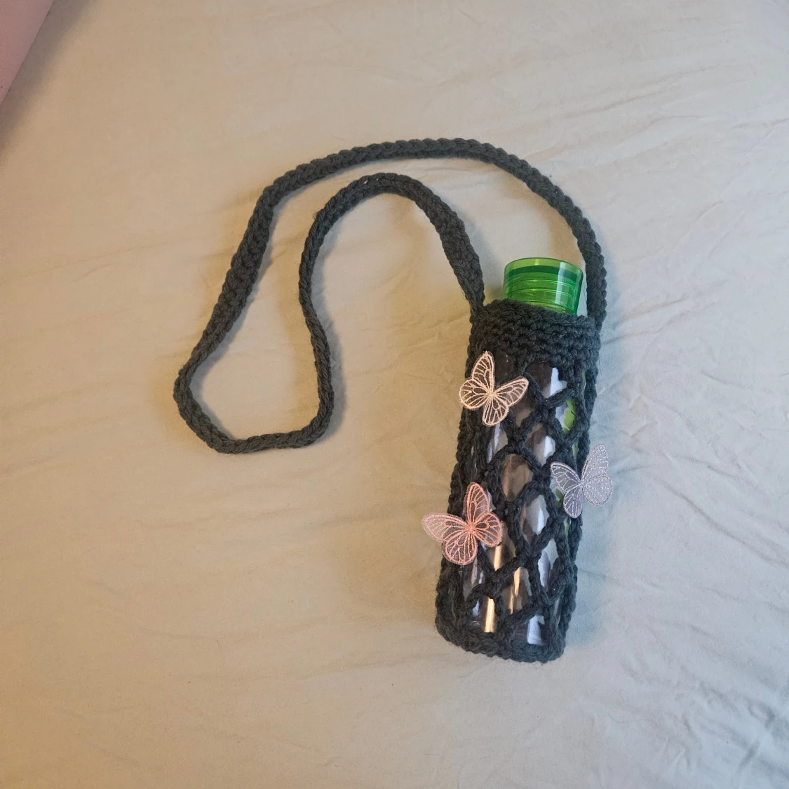 Virkad hållare till flaska med fjärilar