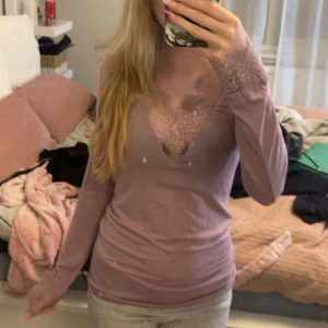 Ljuslila långärmad topp med spets - Säljer en ljuslila långärmad topp med v-ringad spetsdetalj både vid halsen och ärmsluten. Tunn och mjuk, använd en gång men sitter löst på mig och därför säljs. Pris kan diskuteras!