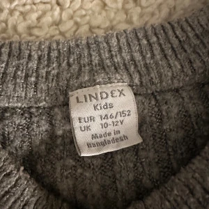 Grå ribbad stickad tröja Lindex - Mysig grå stickad tröja från Lindex med ribbning. Säljer då den inte används. Toppen skick dock lite nopprig💕