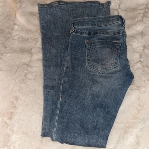 True Religion jeans blå, storlek 25 - Snygga blå jeans från True Religion med fin rosa söm på fickorna. Säljer dem då de tyvärr är för stora för mig! 💞Har vissa defekter som förekom vid deras förra ägare så priset kan diskuteras! 