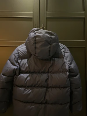 Mörkblå pufferjacka Polo Ralph Lauren - Säljer en mörkblå pufferjacka från Polo Ralph Lauren med luva och broderad logga. Jackan har dragkedja framtill. Perfekt för kalla dagar och har en schysst, oversized vibe. Nypris ca 3200kr, prisförslag mottages 