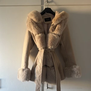 Beige pälsjacka med huva från Giorgia - Säljer en beige pälsjacka från Giorgia med fluffig huva, jackan är i storlek M men är liten i storlek och passar perfekt på mig som har XS. Perfekt för dig som vill ha en cozy och stylish look i vinter. Andvändts fåtal gånger och ser ut som ny🩷