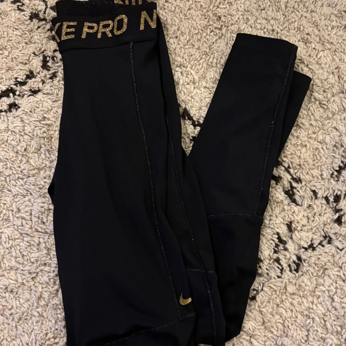 Svarta Nike Pro leggings med guldtext