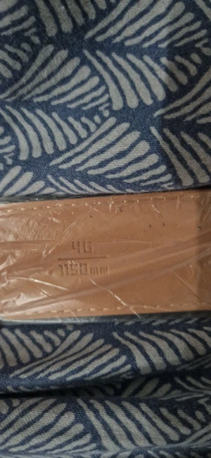 L V rutigt bälte i skinn - (Det är helt nytt och oanvänt)Säljer ett L V bälte i svart och grått med klassiskt rutigt mönster och L V-logga på spännet. Bältet är tillverkat i skinn med beige insida och har en stilren, fyrkantig form. Perfekt accessoar för dig som gillar exklusiva märken och vill ha en snygg detalj till outfiten.