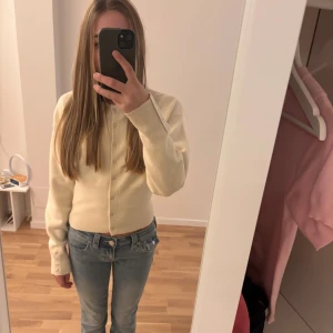 Beige kofta från Gina Tricot - Säljer en beige kofta från Gina Tricot i storlek S. Koftan har rund hals, långa ärmar och knappar framtill. Den är ribbad vid muddar och nederkant, och har en clean, klassisk look som är lätt att matcha med jeans eller kjol. Använd ungefär 2 gånger utanför huset ❤️❤️