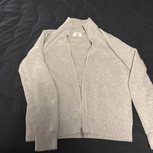 Grå kofta med dragkedja från Bläck - Snygg grå kofta från Bläck i storlek S. Enkel och stilren design som funkar till många. Nypris 799kr, hör av dig vid fler frågor!