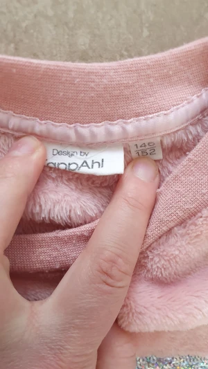 Tröja - Supermjuk och fluffig rosa tröja från KappAhl med lång ärm och rund hals. På bröstet finns en stor silvrig enhörning i paljetter som verkligen sticker ut. Perfekt för dig som gillar glittriga detaljer och vill ha något extra mysigt.