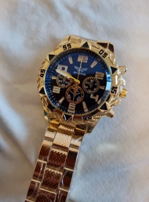 Guldig klocka med blå urtavla från Zhowie - Snygg klocka från Zhowie med guldig länk i rostfritt stål och blå urtavla med flera subdials. Klockan har markerade siffror och detaljer i guld och svart på boetten. Länken har en cool textur och klockan levereras i original ask.