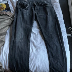 Svarta skinny jeans från dondup, strl 33, modell ”George” - Svarta jeans från George i skinny fit-modell. Klassisk femficksdesign med smal passform och snygga detaljer vid fickorna. Jeansen är tillverkade i ett stretchigt denimtyg som sitter tajt och bekvämt. Perfekt för dig som gillar en modern och stilren look.