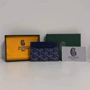 Blå G yard plånbok med mönster - Snygg och stilren blå plånbok från G yard med ikoniskt grafiskt mönster i vitt och grått. Plånboken är tunn och smidig, perfekt för kort och sedlar. Materialet är lyxigt skinn med klassisk G yard-logga framtill. Kommer med original ask och tyg.